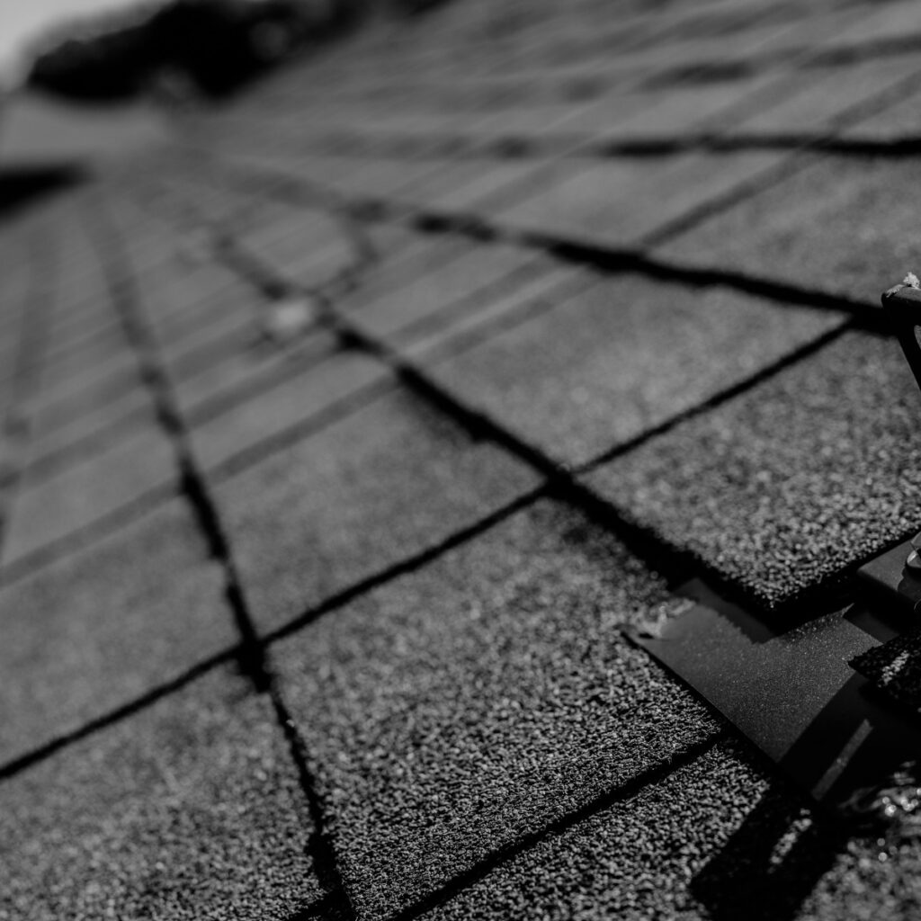 closeup of asphalt shingle roof with solar panel bracket