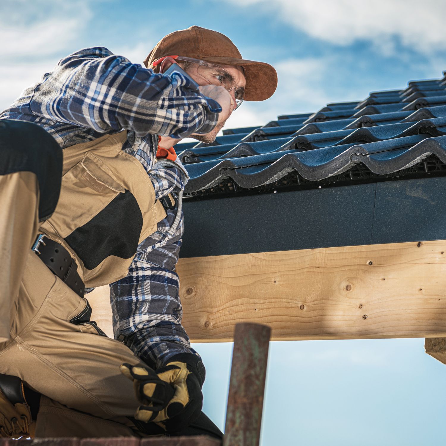 roofer on the roof on a cell phone